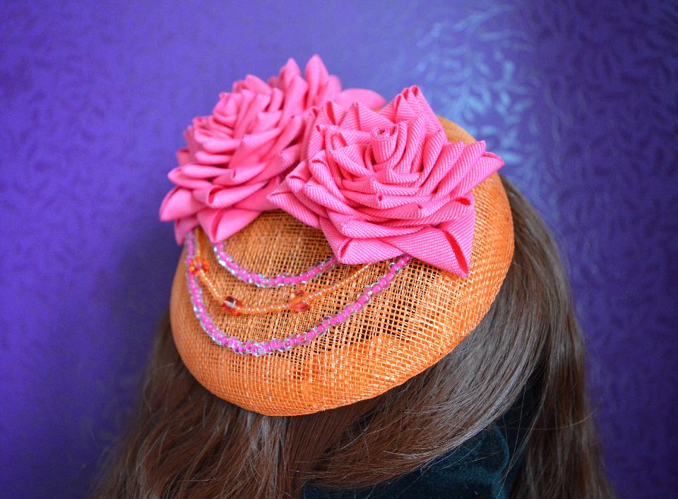 IMAGE - Orange sinamay fascinator with pink folded ribbon lotuses. Finished with pink and orange beads. Fixes to hair with a comb.
