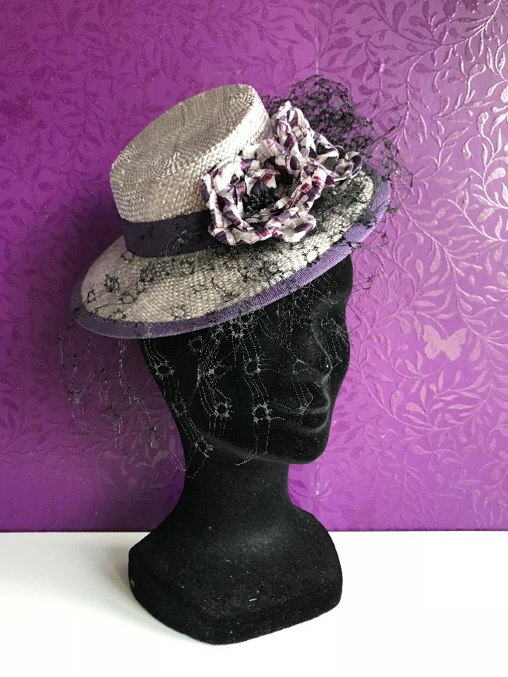 IMAGE - Silver handblocked straw mini hat. Decorated with vintage black veil and handmade purple silk flowers, finished with purple ribbon. Stays on the head with wigclips.