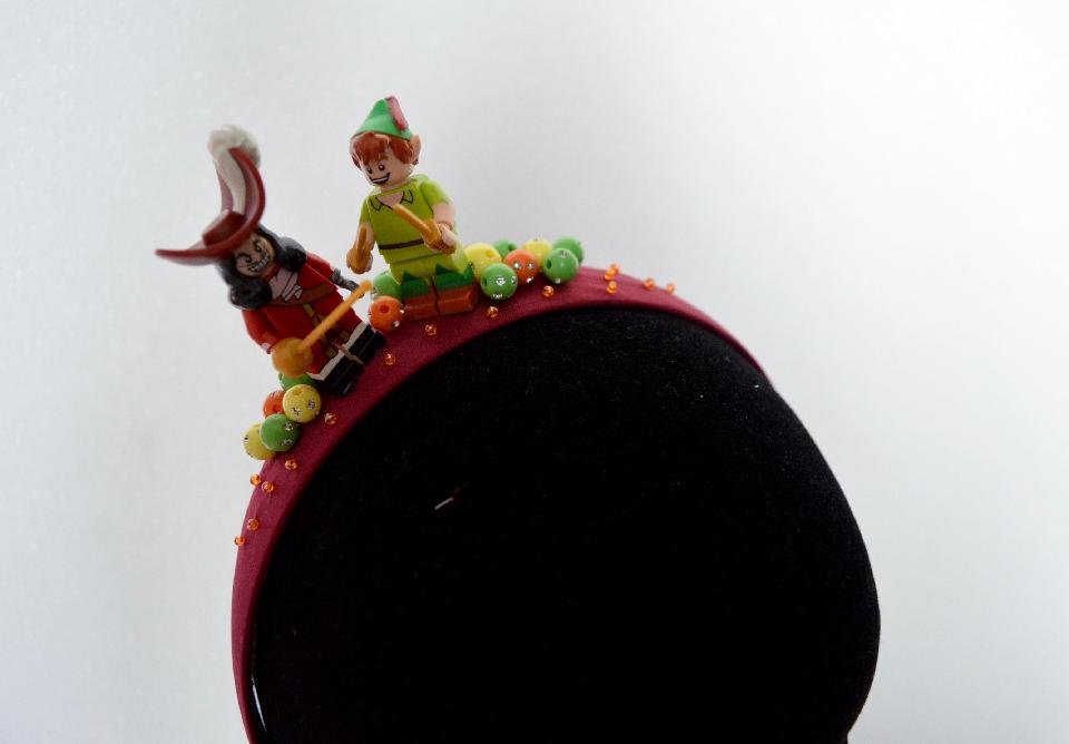 IMAGE - Burgundy satin headband decorated with Peter Pan and Hook figurine. Finished with beads. 