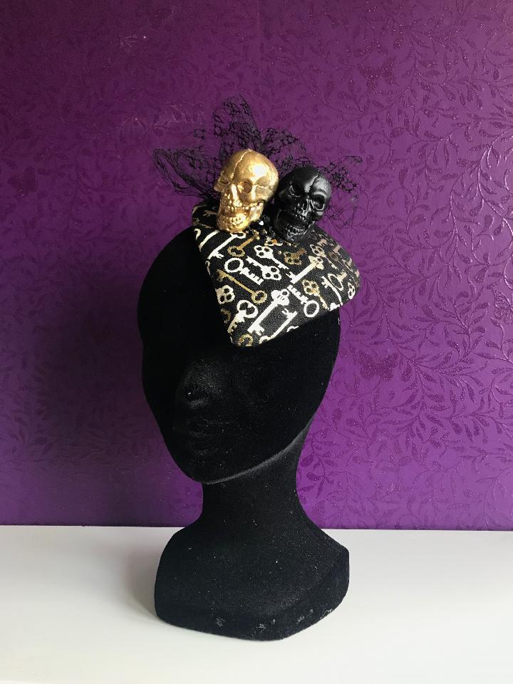 IMAGE - Handblocked heartshaped fascinator covered with black and gold fabric. Decorated with black vintage voillette and black and gold skulls. Finished with some beads. Fixes to the hair with wig clips. 
