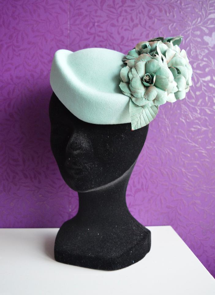 IMAGE - Handblocked light blue felt pillbox hat, decorated with handmade silk camelias. 
Fixes to hair with an elastic. 
