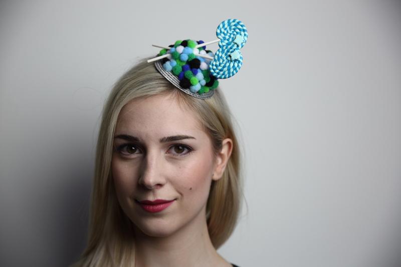 IMAGE - Silver mini fascinator decorated with green, blue, white and black ponpons and handmade polymer clay lollipops. Fixes to hair with a comb.